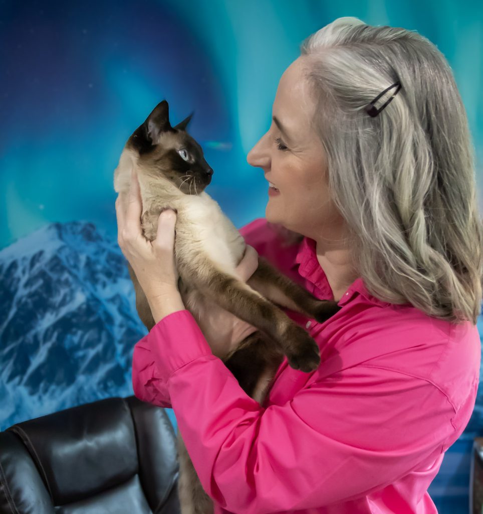 Jennifer Swann holding her cat. She is smiling and staring into the cat's eyes.