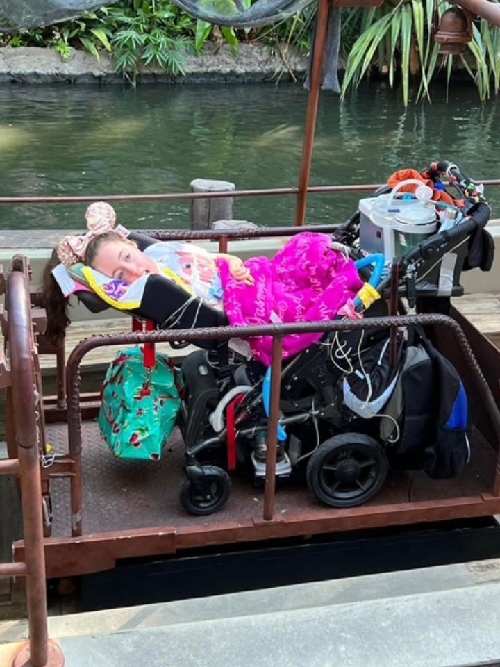 Kennedy on a wheelchair lift in a tropical location.