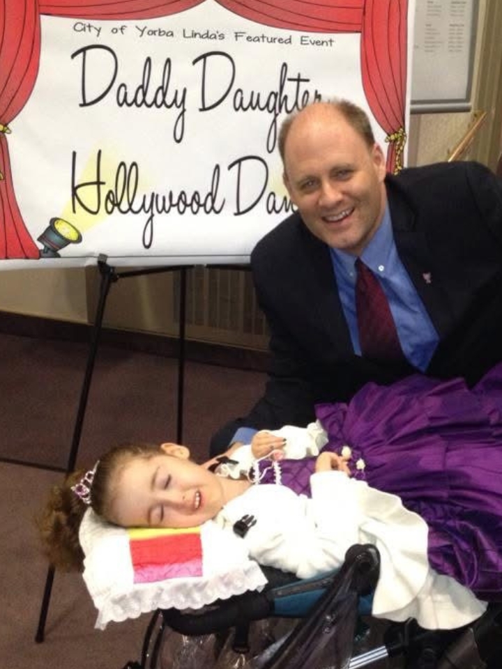 Kennedy Swann and her father pose together in formal dress at a Daddy-Daughter Hollywood Dance.