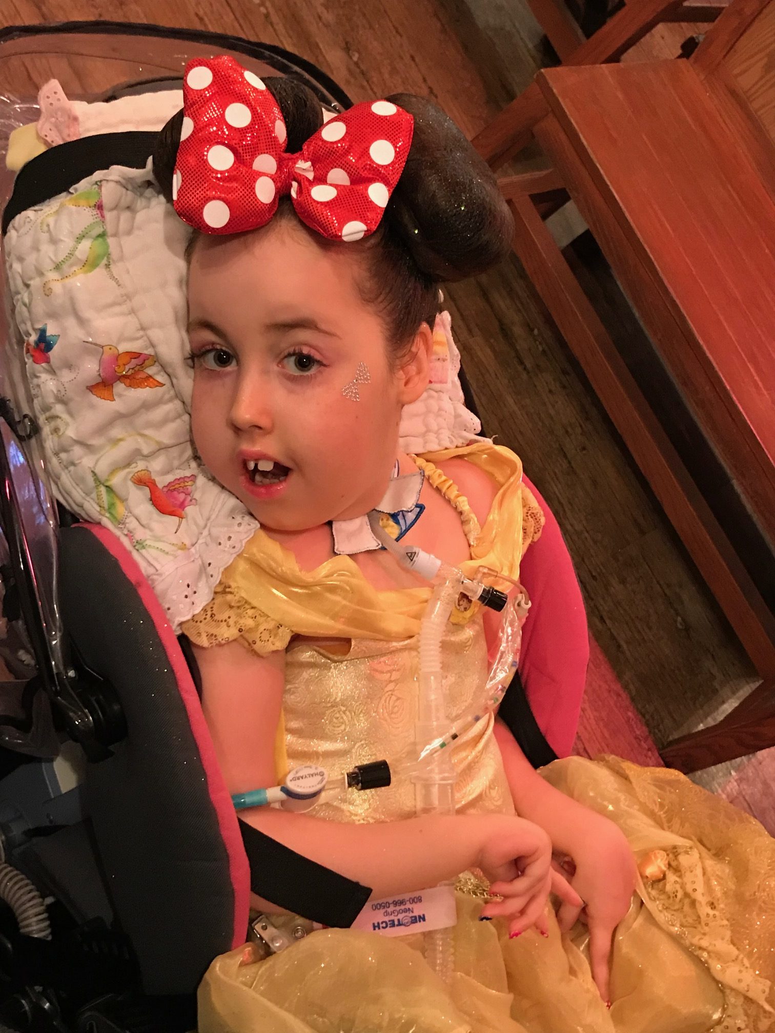 A young Kennedy Swann dressed as Minnie Mouse with a yellow dress.